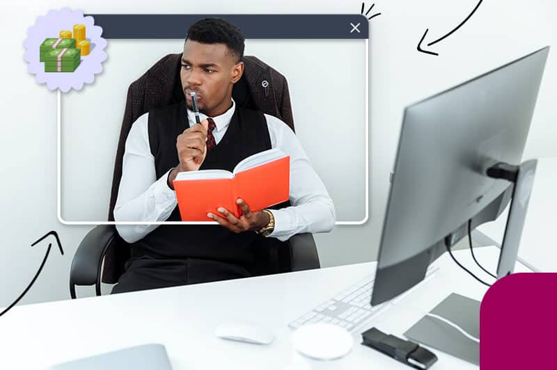 black man sitting at desk holding journal and pen