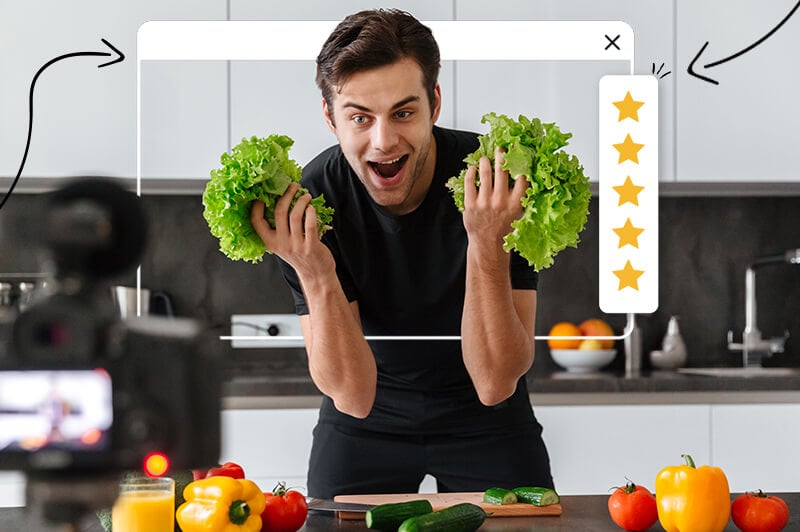 happy man holding up lettuce in front of a camera