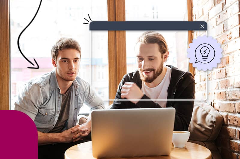 two men sitting in front of computer