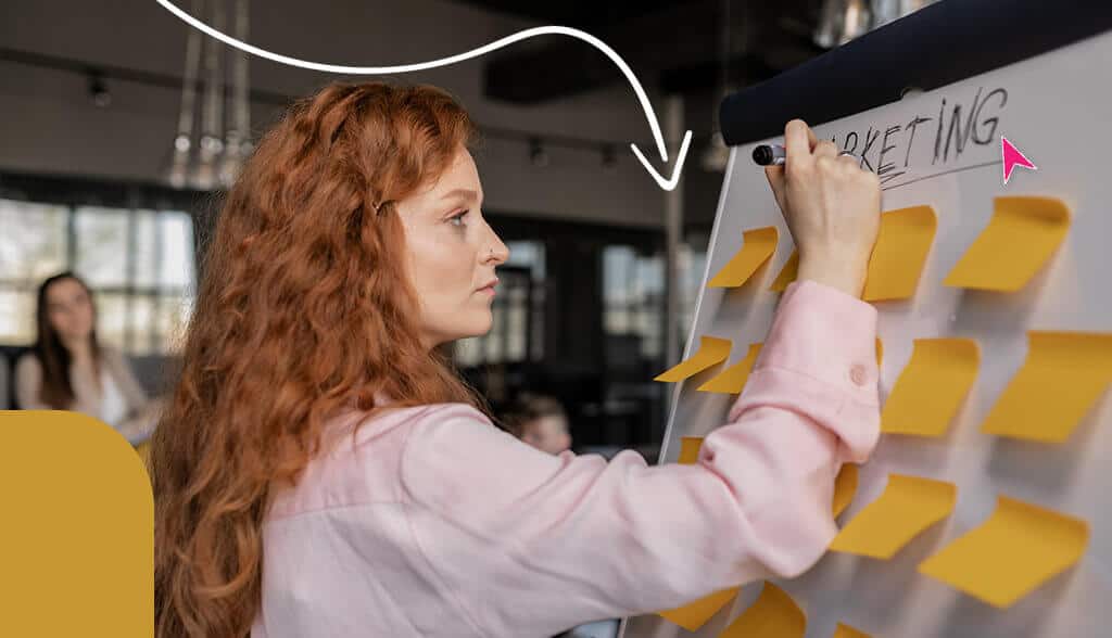 red head woman writing on white board